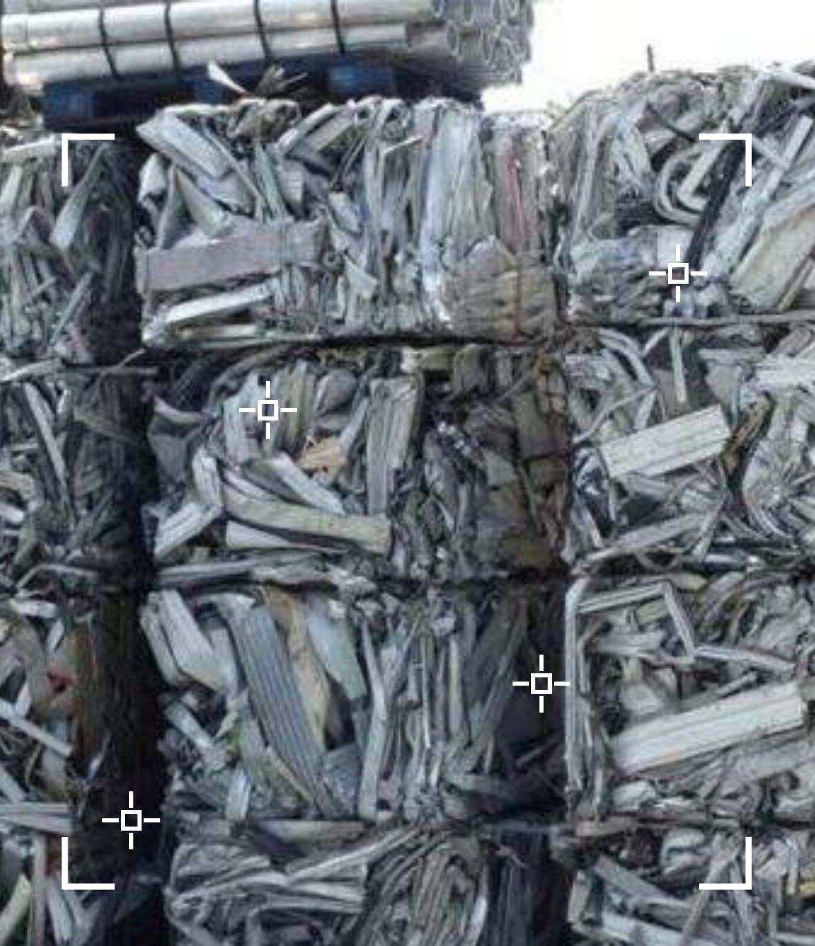 Bales of compacted aluminum stacked in a recycling yard